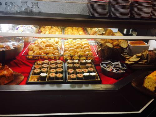 una vitrina con muchos tipos diferentes de donuts en Logis Hotel Lons-le-Saunier - Restaurant Le Grill, en Lons-le-Saunier