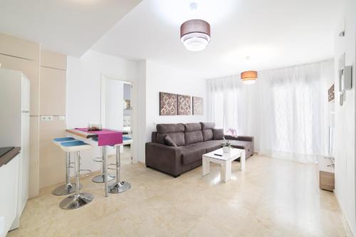 a living room with a couch and a table at Apartamentos Salamanca in M&aacute;laga