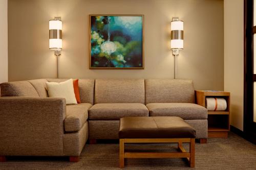 a living room with a couch and a painting at Hyatt Place Sterling Dulles Airport North in Sterling