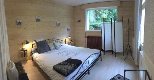 a bedroom with a bed in a wooden wall at La Maison Du Bulot in Fruges