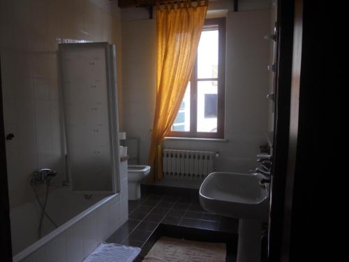 een badkamer met een wastafel, een toilet en een raam bij Agriturismo Boaria Bassa in Castel dʼArio