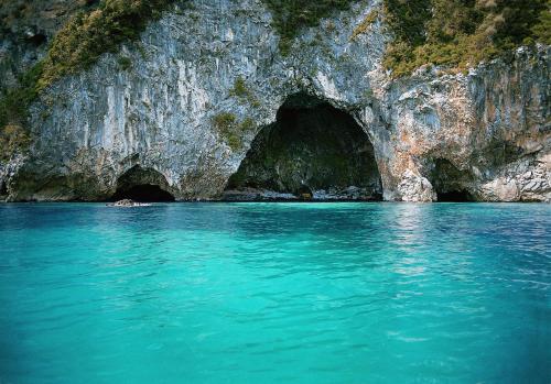 two tunnels in the side of a cave in the water at Archontiko Elda in Agios Dimitrios