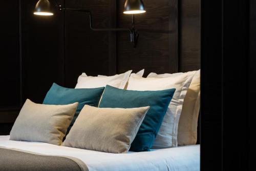 a bed with blue and white pillows on it at Hôtel Du Dragon in Strasbourg