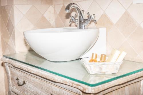 a white sink on a glass counter in a bathroom at Masseria Luco in Martina Franca