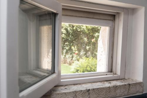 an open window with a view of a yard at Masseria Luco in Martina Franca