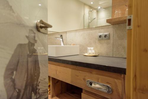 La salle de bains est pourvue d'un lavabo et d'un miroir. dans l'établissement Apart Hotel San Antonio, à Sankt Anton am Arlberg
