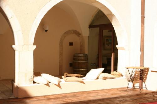 ein Zimmer mit einem Sofa mit Kissen und einem Fass in der Unterkunft Convento di San Colombo in Santo Stefano di Sessanio