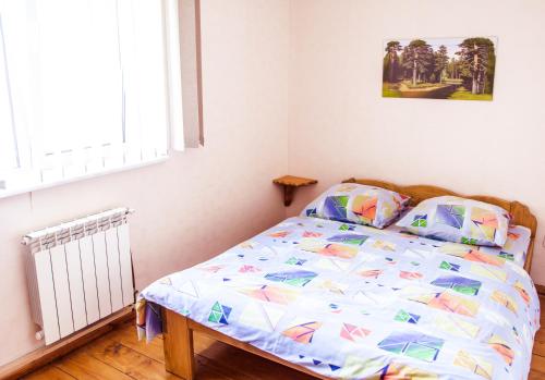 a bedroom with a bed with a comforter and pillows at Tsisarske Urochyshe in Rozgirche