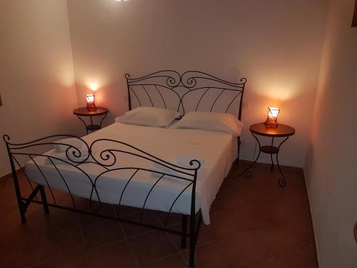 a bedroom with a bed with two side tables at Appartamenti Le Gemme in Palau