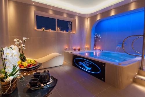 a bathroom with a blue tub and a table at Hotel Lido in Cattolica