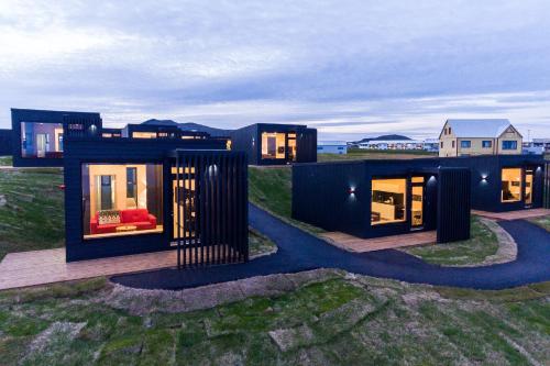 a black house on top of a field at Harbour View Cottages Grindavik in Grindavík
