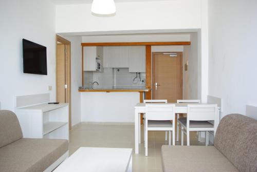 uma sala de estar com mesa e cadeiras e uma cozinha em Apartamentos Embat em Can Pastilla