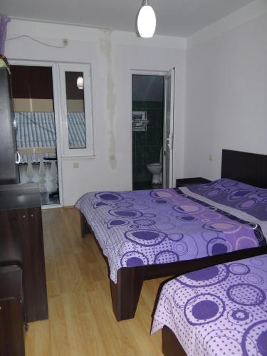a bedroom with a purple bed and a bathroom at Festina Lente in Kobuleti