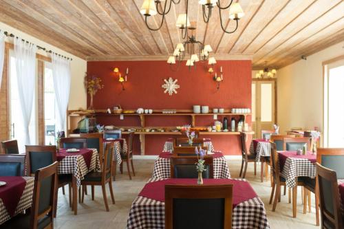 um restaurante com paredes vermelhas, mesas e cadeiras em Don Quixote Pousada em Tiradentes