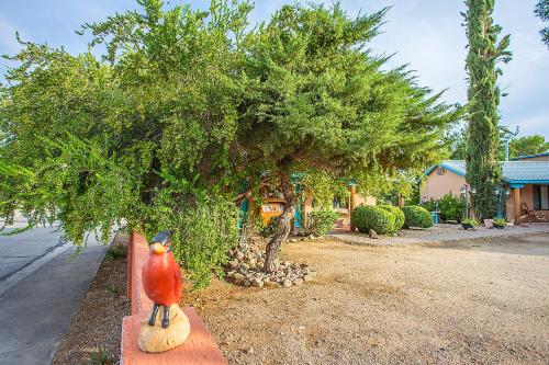 a bird statue sitting on a fence next to a tree at My Place Suites in Wickenburg