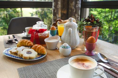 a table with a breakfast of pastries and coffee and eggs at Apartment Hotel Christine in Avelengo