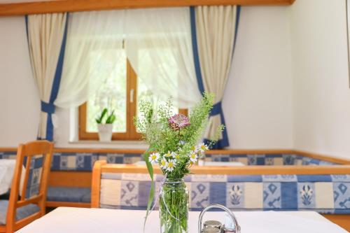 een vaas gevuld met bloemen op een tafel bij Haus Spieleck in Saalbach Hinterglemm