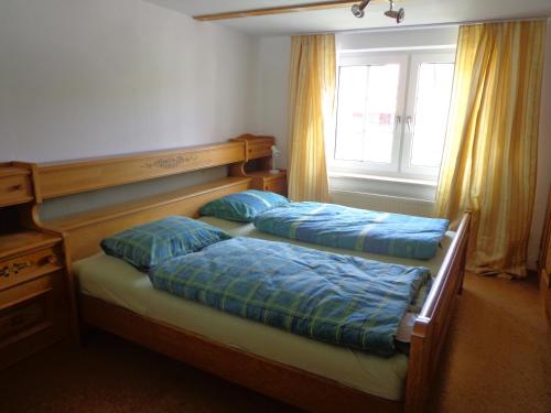 2 Betten mit blauen Kissen im Schlafzimmer in der Unterkunft Ferienwohnung Valora in Obergude