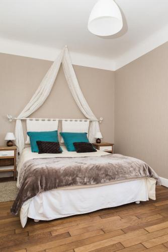 a bedroom with a canopy bed with blue pillows at Chambre d'hôte l'épineuse in Venarey-les-Laumes