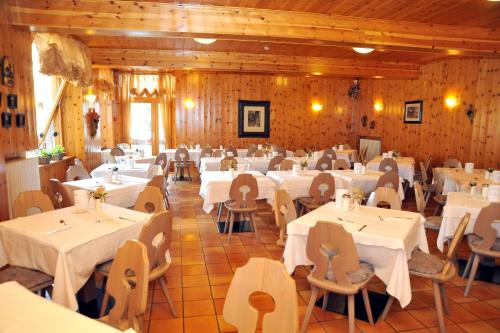 a dining room with white tables and chairs at Albergo Stelvio in Bormio