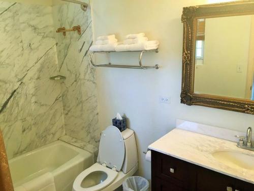 a bathroom with a toilet and a sink and a mirror at Ocean West Boutique Hotel in Nassau