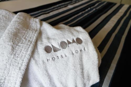 a towel on a bed with the word normal love on it at ONOMO Hotel Lomé in Lomé