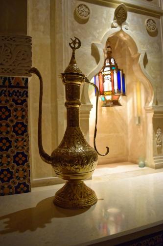 a gold vase sitting on a table next to a lamp at OCEANA Hotel & Spa in Hammamet