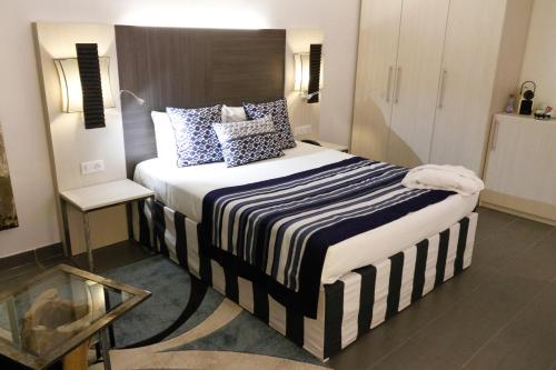 Una cama o camas en una habitación de ONOMO Hotel Lomé