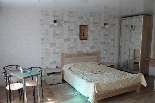 een slaapkamer met een bed en een tafel en stoelen bij Studio on main street in Bălţi