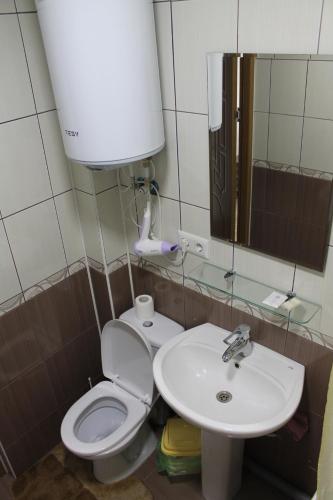een badkamer met een toilet, een wastafel en een spiegel bij Studio on main street in Bălţi