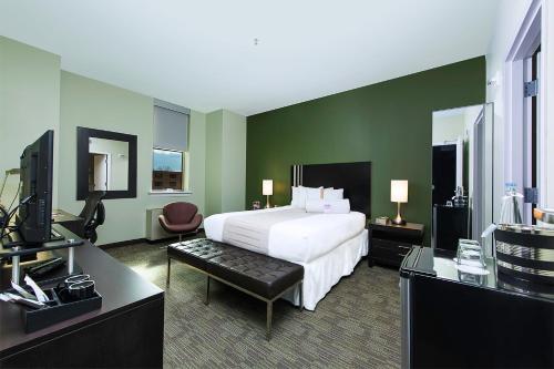 ワシントンにあるKellogg Conference Hotel Capitol Hill at Gallaudet Universityの白いベッドと緑の壁のある寝室