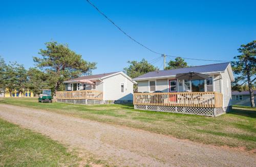 a house with an umbrella on a dirt road at Cavendish Lodge & Cottages in Cavendish