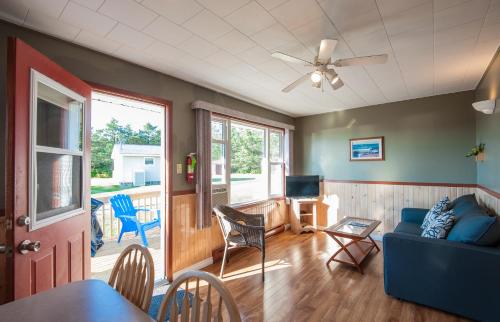 a living room with a blue couch and a tv at Cavendish Lodge & Cottages in Cavendish