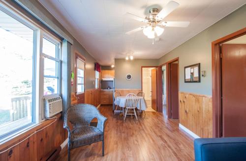 a living room with a table and chairs and a ceiling fan at Cavendish Lodge & Cottages in Cavendish