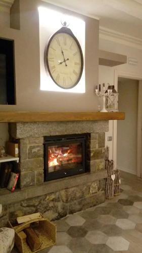 a clock hanging above a fireplace with a fire place at Ca' Baetti l'Antica Corte in Roncola