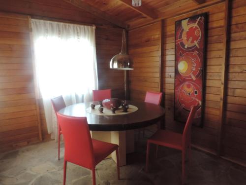 a dining room with a table and red chairs at Rancho los Madroños in Villa del Carbón
