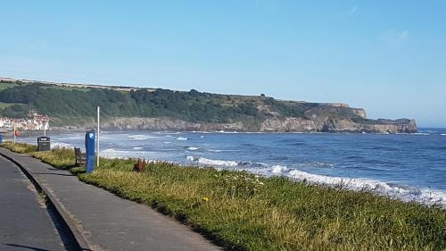 a road next to a beach with the ocean at Rowan Tree House B&B in Sleights