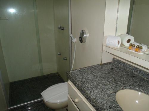 a bathroom with a shower and a toilet and a sink at Iracema Residence Hotel Flat in Fortaleza