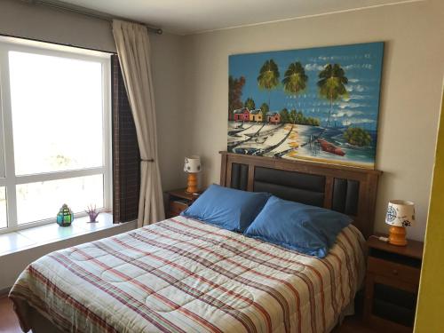 1 dormitorio con 1 cama y una pintura en la pared en Camino del Alto en Reñaca, en Viña del Mar