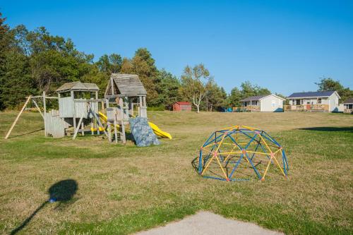 a park with a playground and a play structure at Cavendish Lodge & Cottages in Cavendish