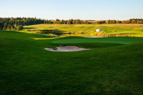 an aerial view of a golf course with a pond at Cavendish Lodge & Cottages in Cavendish