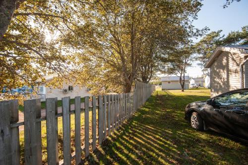a car parked in a yard next to a fence at Cavendish Lodge & Cottages in Cavendish