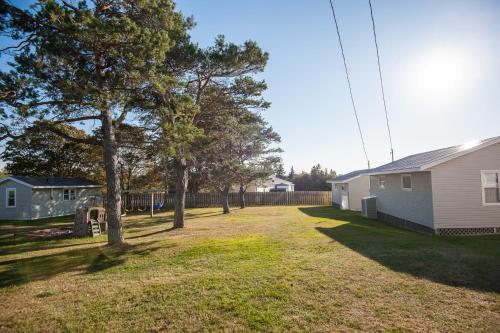 an empty yard next to a house and trees at Cavendish Lodge & Cottages in Cavendish