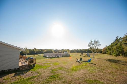 a large yard with people sitting on chairs in the grass at Cavendish Lodge & Cottages in Cavendish