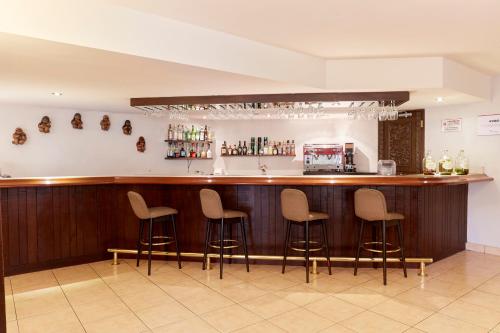 a bar with four stools in a room at Hotel Carrera in Lima