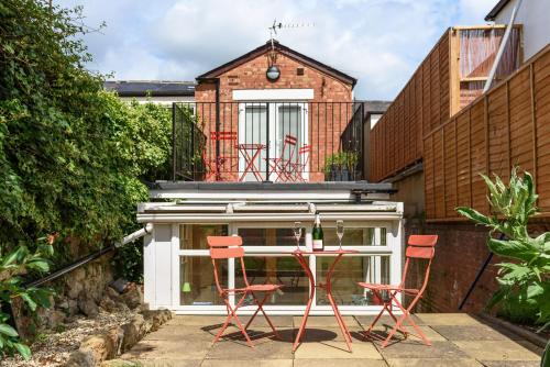 a group of red chairs and a table on a patio at 5b North Parade Avenue in Oxford