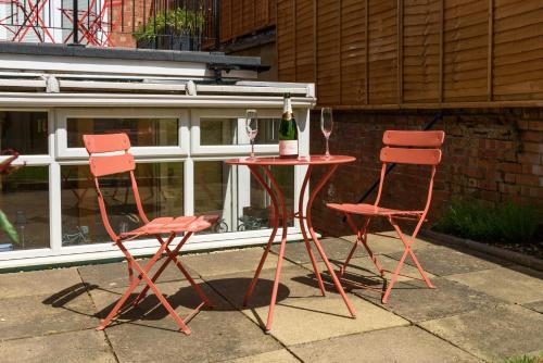 two chairs and a table with a bottle of wine at 5b North Parade Avenue in Oxford