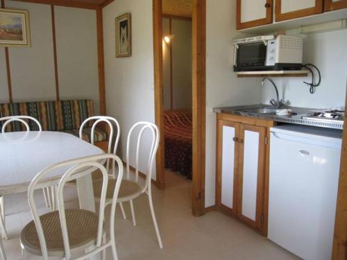 a kitchen with a table and chairs and a microwave at Chalet Des Menhirs in Moulin-Mage