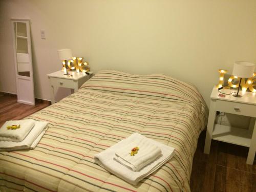 um quarto com uma cama com toalhas e luzes em Pasaje Claro em Neuquén