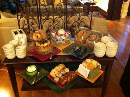a table filled with different types of bread and pastries at Lyndon House Bed & Breakfast in Lexington